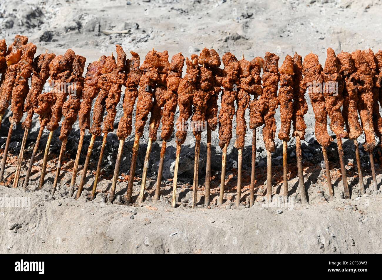 NIGER, villaggio Namaro, barbecue di carne al mercato rurale, spiedino di carne, carne di capra su bastoni di legno che grigliano intorno al fuoco / Markttag, Fleisch Grill Stand, Fleischspiesse Foto Stock