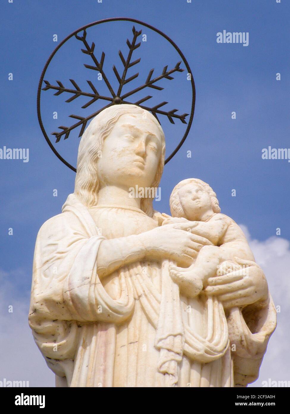 Guardando in alto una statua a Praiano, Italia. Costiera Amalfitana. Madonna e Bambino su sfondo blu. Alone. Simbolo religioso. Da sotto. Foto Stock