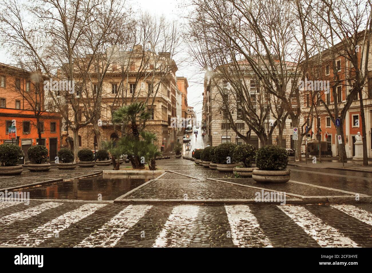 Bella strada piovosa di Roma con le persone sotto le sagome ombrello per il design lifestyle. Stagione estiva. Sfondo scuro e moody. Bella romantica Foto Stock