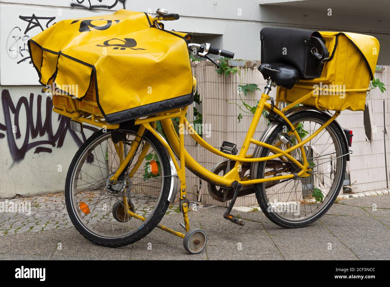 Bicicletta di un postino degli stand dell'Ufficio postale tedesco sul  marciapiede Foto stock - Alamy