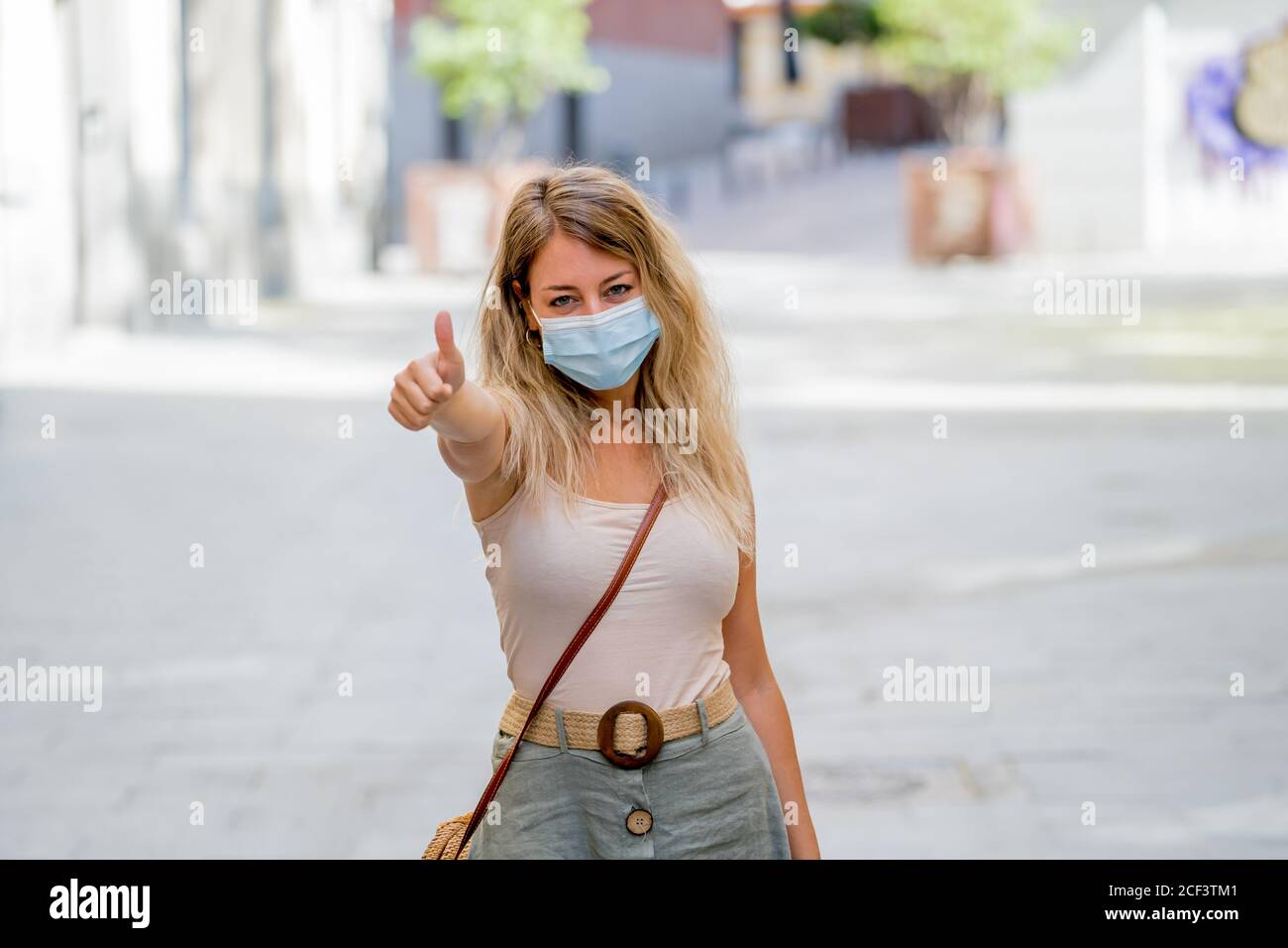 Giovane donna che indossa una maschera protettiva all'aperto nella strada della città. Immagine positiva di Nuova vita normale dopo COVID-19 e protocolli sanitari per evitare infec Foto Stock