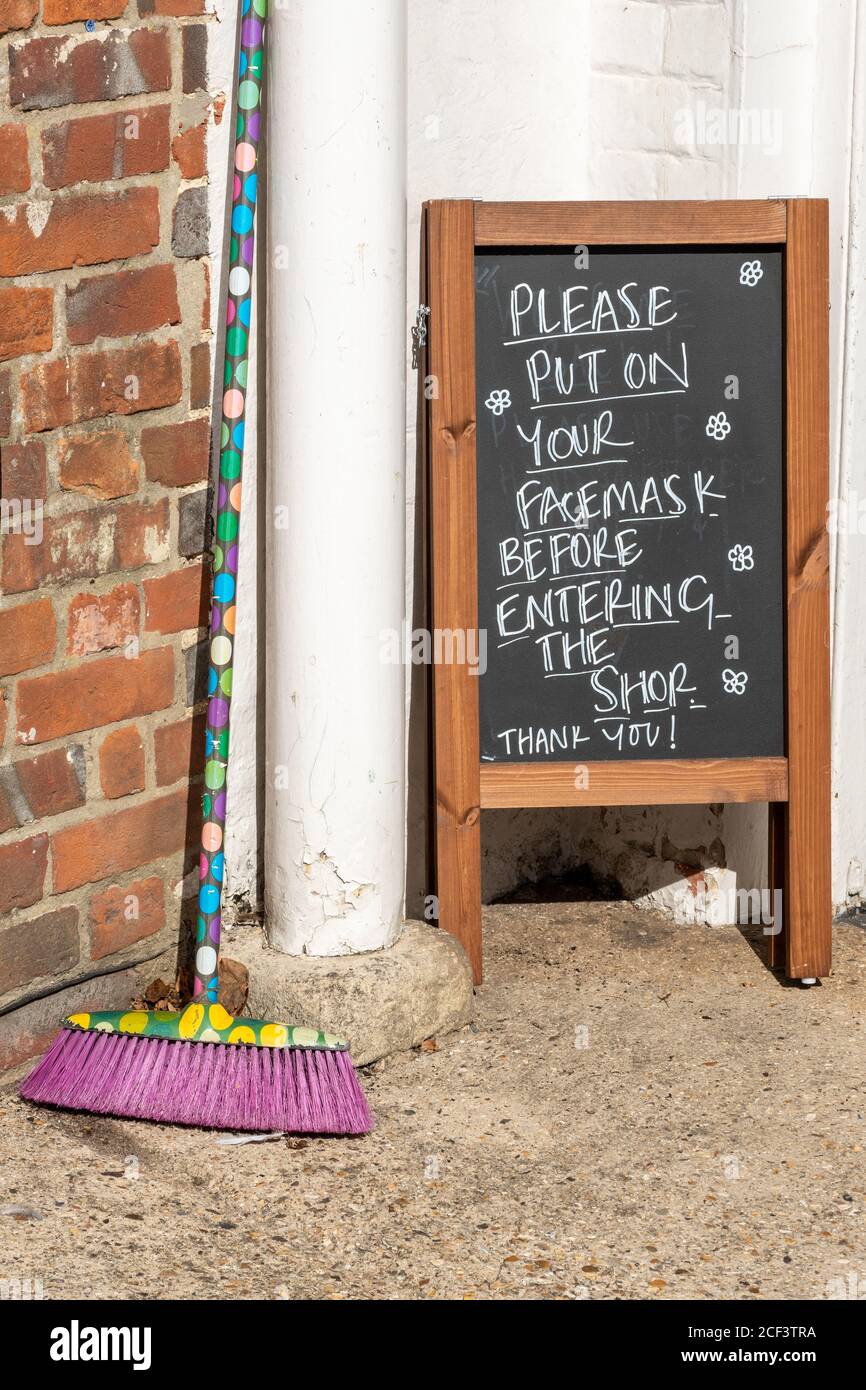 Avviso all'esterno di un negozio chiedendo ai clienti di indossare il facemask prima di entrare durante la pandemia del 2020 Coronavirus covid-19, Regno Unito Foto Stock