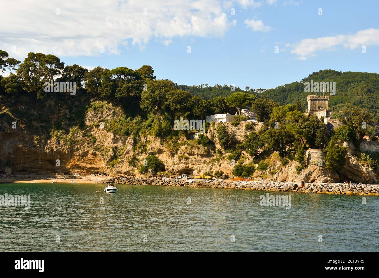 Vista dal mare della costa con il castello di San Terenzo (XVI secolo) su uno sperone roccioso in estate, la Spezia, Liguria, Italia Foto Stock