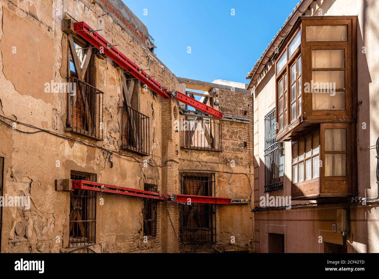 Lavori di costruzione che consistono nel sostenere una facciata medievale in acciaio Travi nel centro storico di Toledo Foto Stock