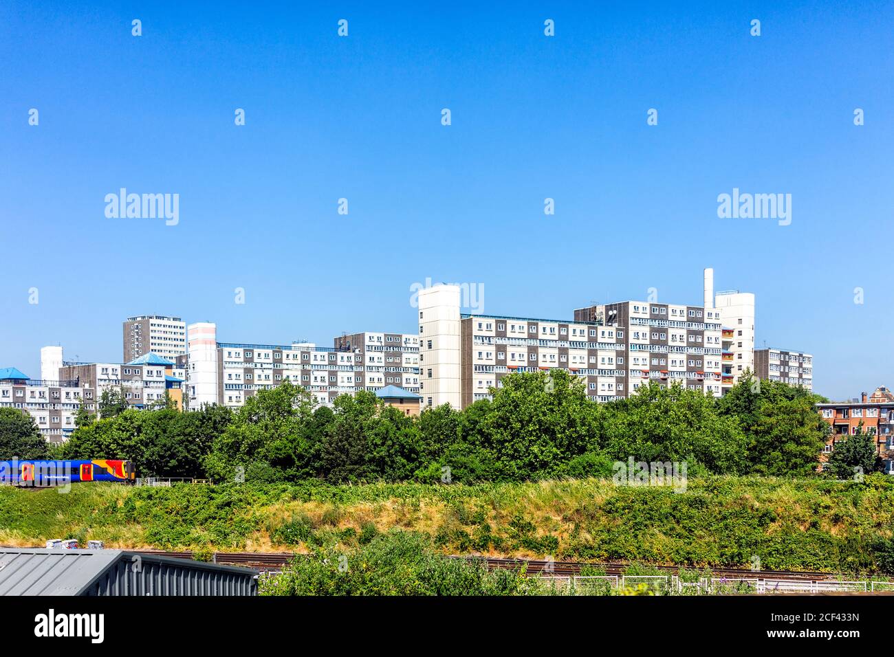 Horley, Regno Unito - 27 giugno 2018: Stazione della metropolitana South Western dell'aeroporto di Gatwick con linea rossa e blu e moderno edificio di appartamenti Foto Stock
