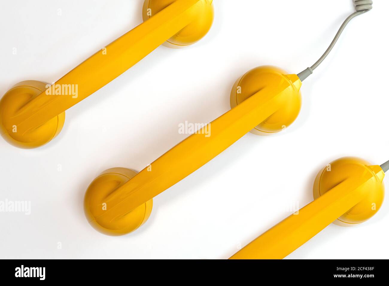 Modello composto da un telefono di colore giallo su sfondo bianco. Moderno stile retrò. Nuova vecchia tecnologia. Foto Stock
