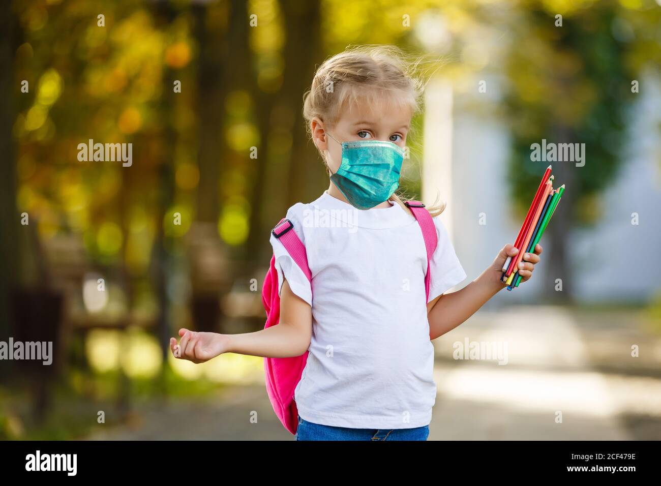 Bambina studente che indossa una maschera medica protettiva a scuola, epidemia, diffusione di Coronavirus, Covid-19, studentessa con maschera per prevenire Corona Foto Stock