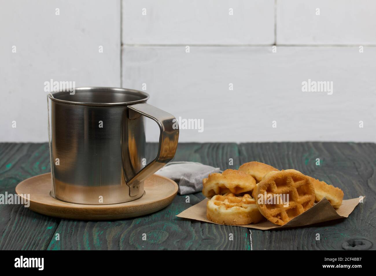 Tazza di tè e waffle. Nelle vicinanze si trova una borsa per il tè. Su tavole verniciate. Autunno ancora vita. Foto Stock