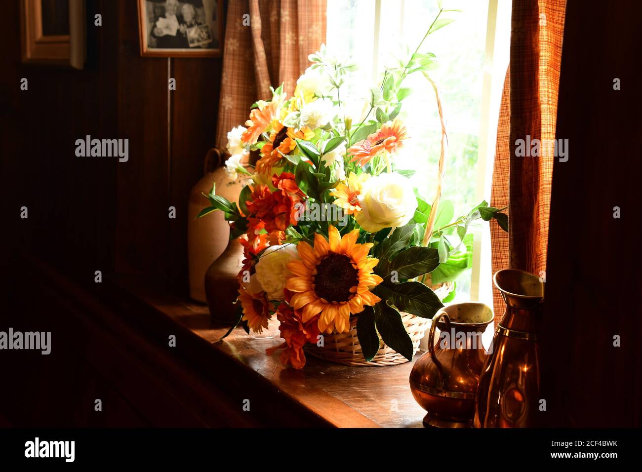 Disposizione colorata dei fiori con brocche di rame e contenitori di terracotta su Un davanzale soleggiato in una casa pubblica in Devon.UK Foto Stock