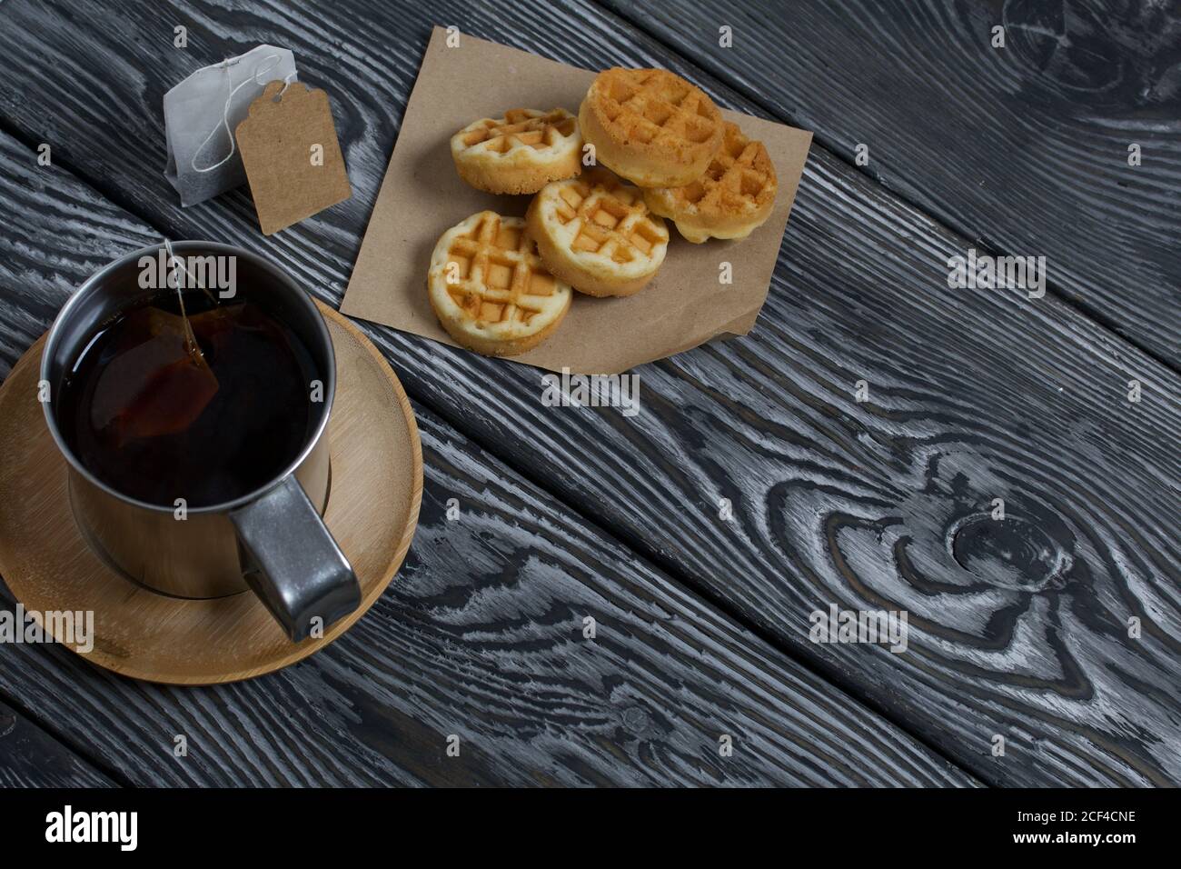 Tazza di tè e waffle. Nelle vicinanze si trova una borsa per il tè. Su tavole verniciate. Autunno ancora vita. Foto Stock