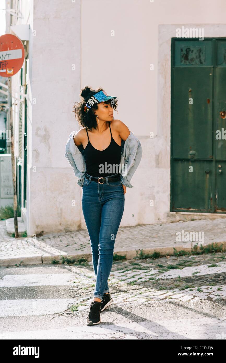 Giovane donna afro-americana allegra in jeans e t-shirt nera in strada città di giorno Foto Stock