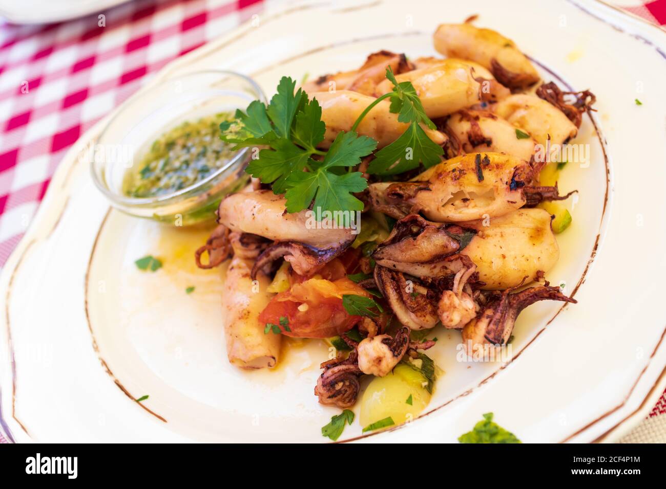 Deliziosi calamari alla griglia con verdure sul piatto Foto Stock