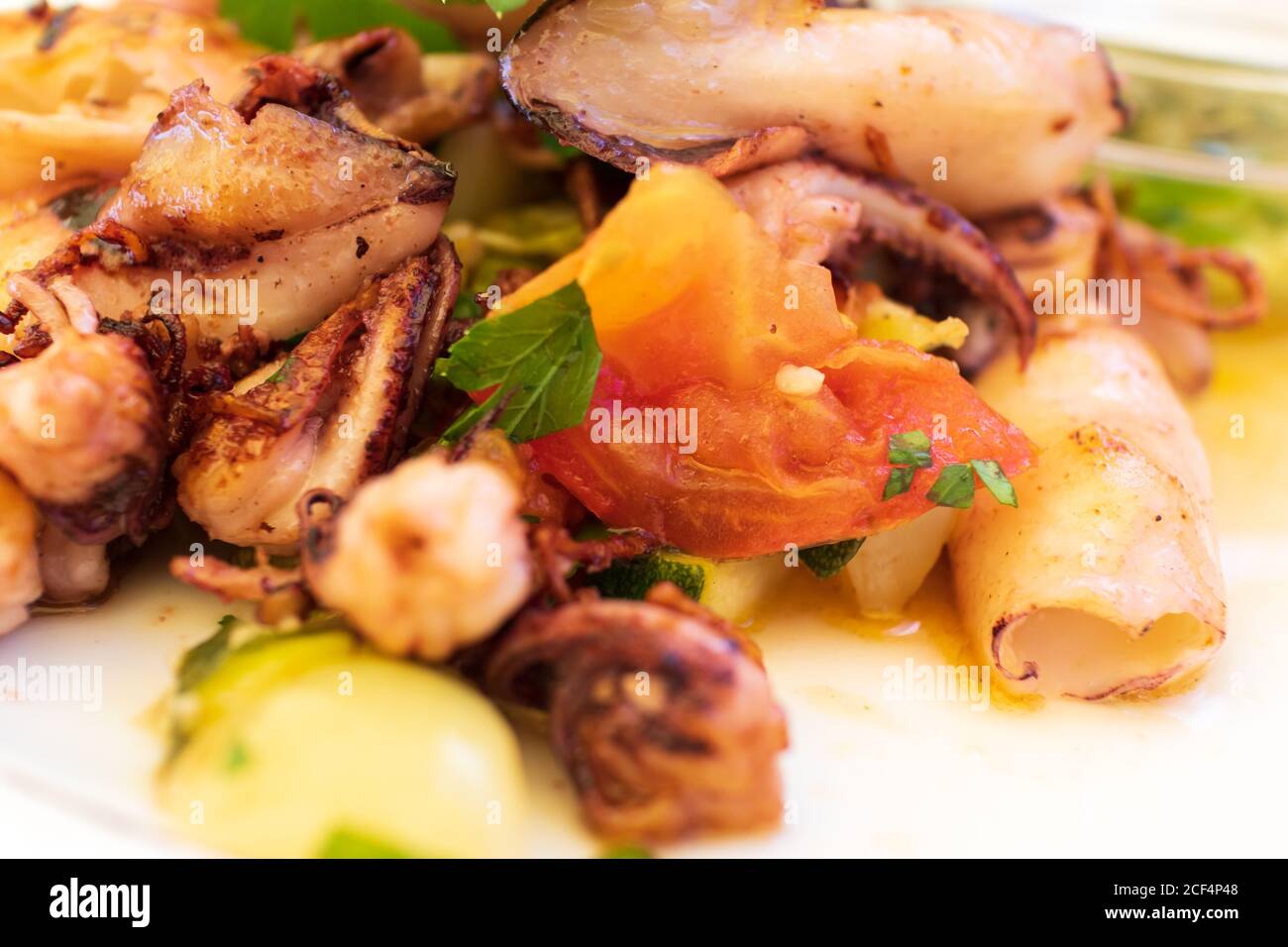 Deliziosi calamari alla griglia con verdure sul piatto Foto Stock