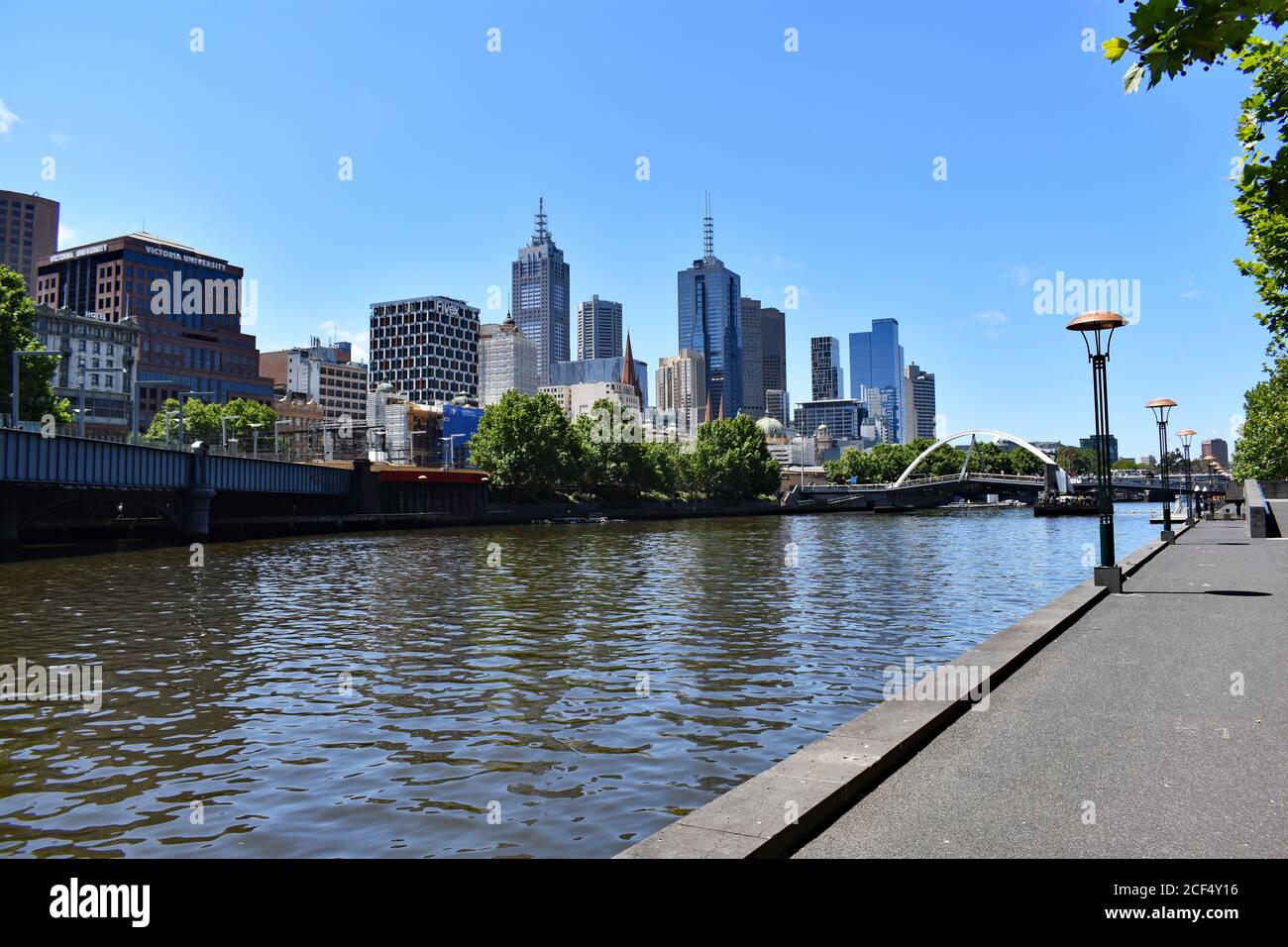 Guardando lungo il fiume Yarra nel centro di Melbourne dalla Southbank Promenade. E' una giornata di sole e senza pedoni che camminano lungo la riva del fiume Foto Stock