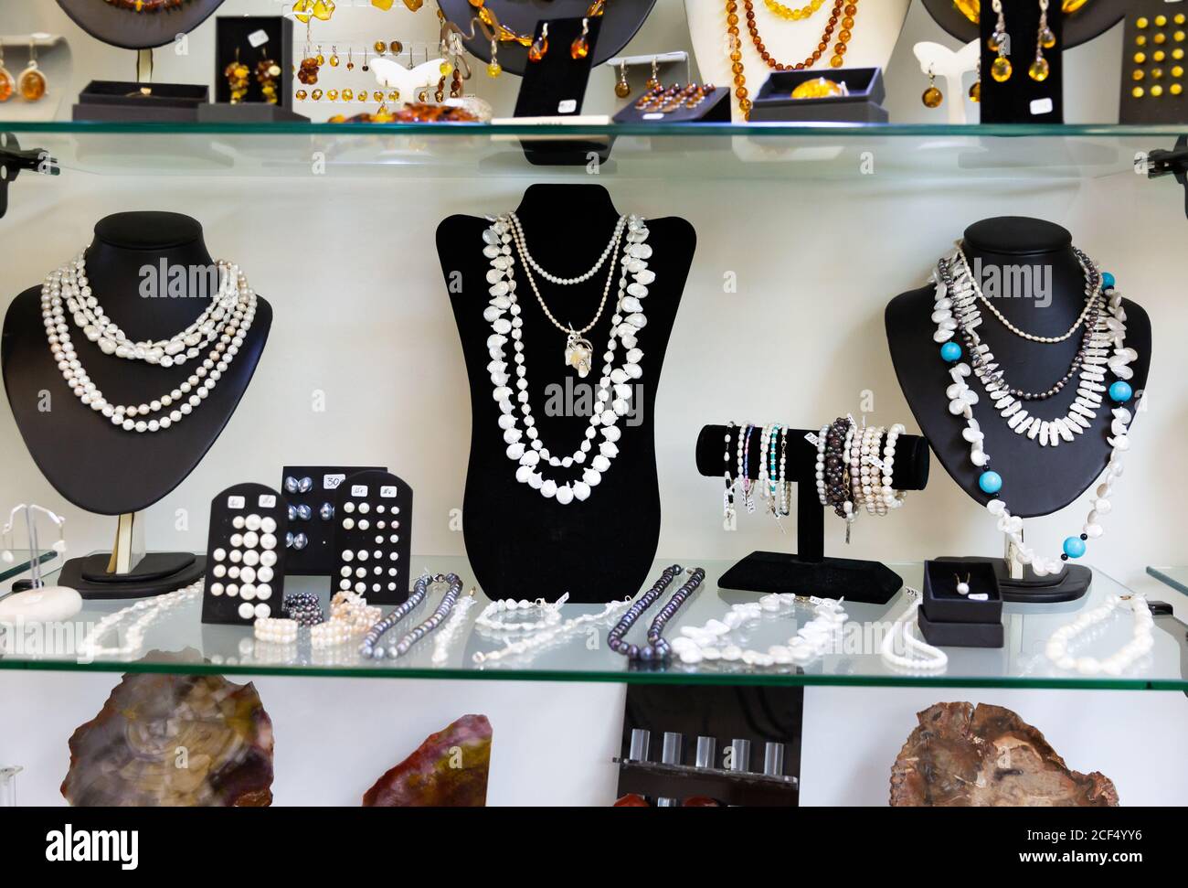 Varietà di collane, bracciali e orecchini in perle bianche e nere su  manichini in negozio gioielli finestra Foto stock - Alamy