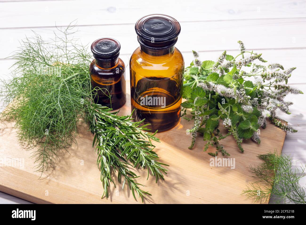 Olio essenziale di erbe. Olio di menta peperita, rosmarino e finocchio per aromaterapia, benessere, cura della pelle, rimedi alle erbe Foto Stock