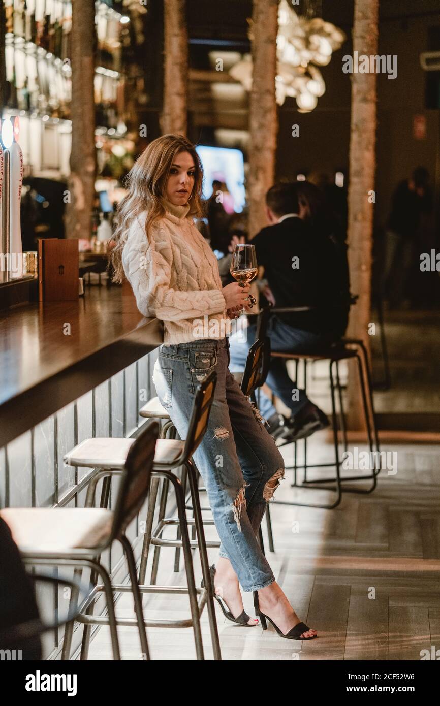 Donna elegante bere vino al bar Foto Stock