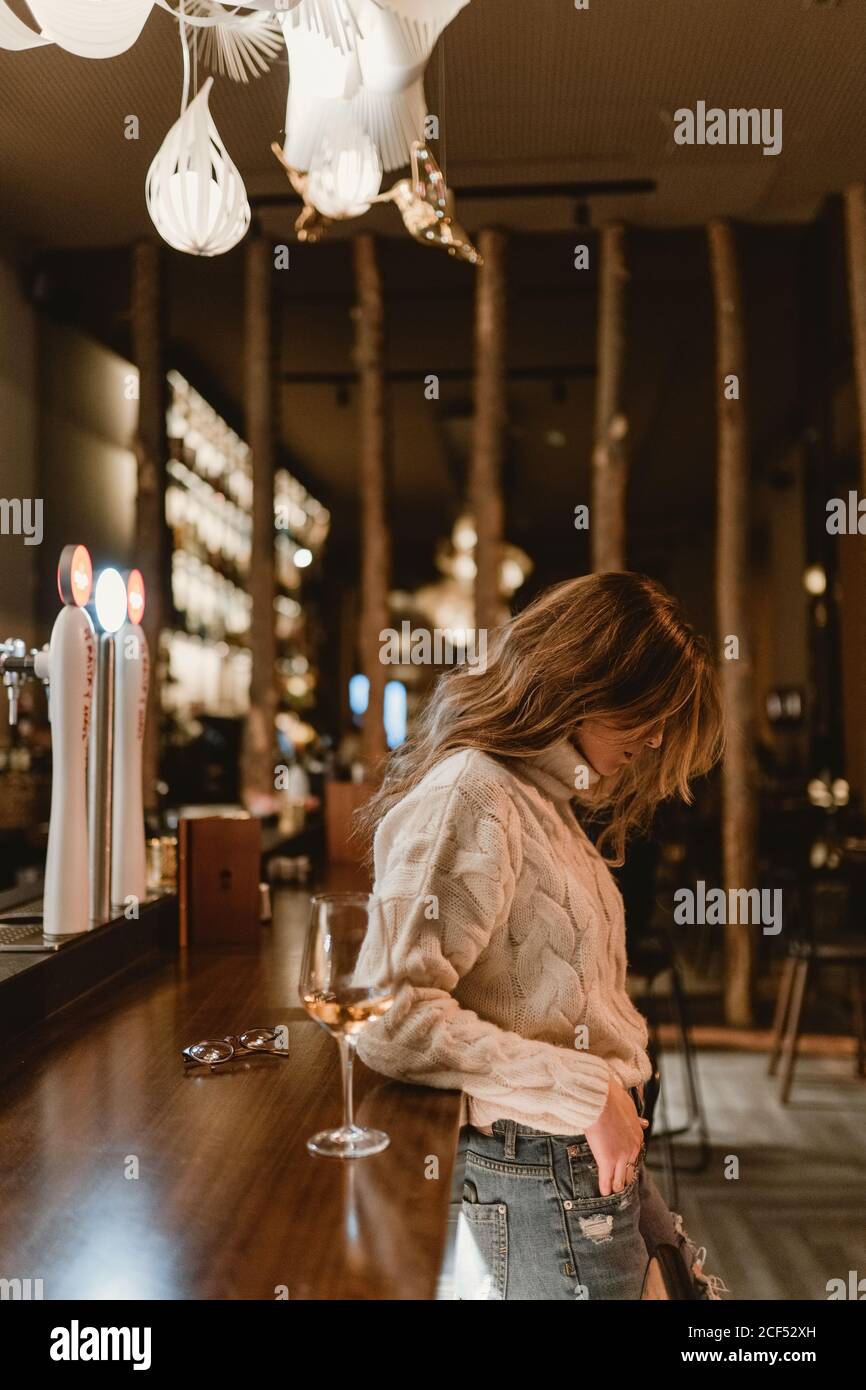 Donna elegante bere vino al bar Foto Stock