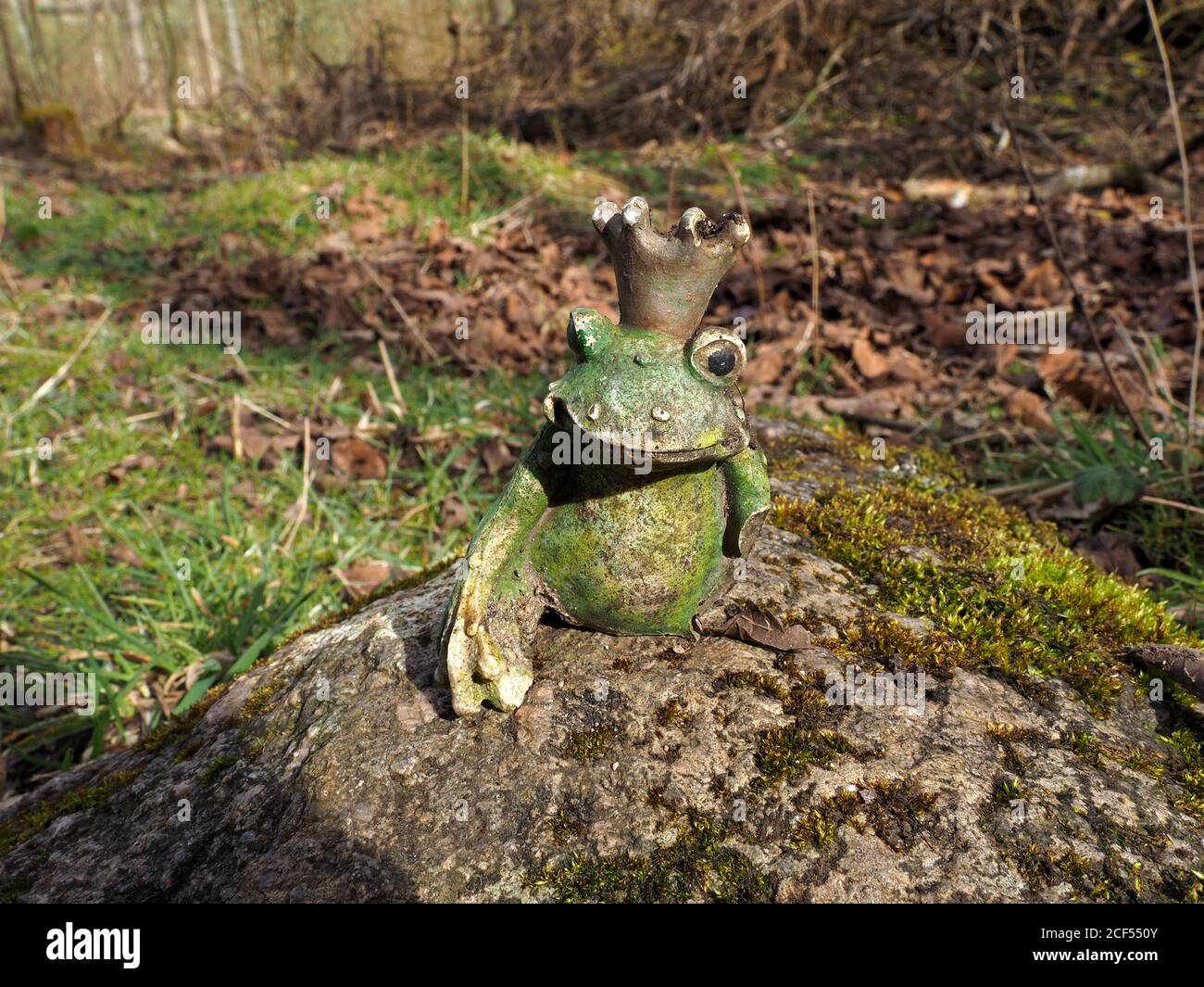 Objet Trouve, un modello di ceramica danneggiato bizzarro di una rana coronata trovato abbandonato e arroccato su una roccia in Cumbria, Inghilterra, Regno Unito Foto Stock