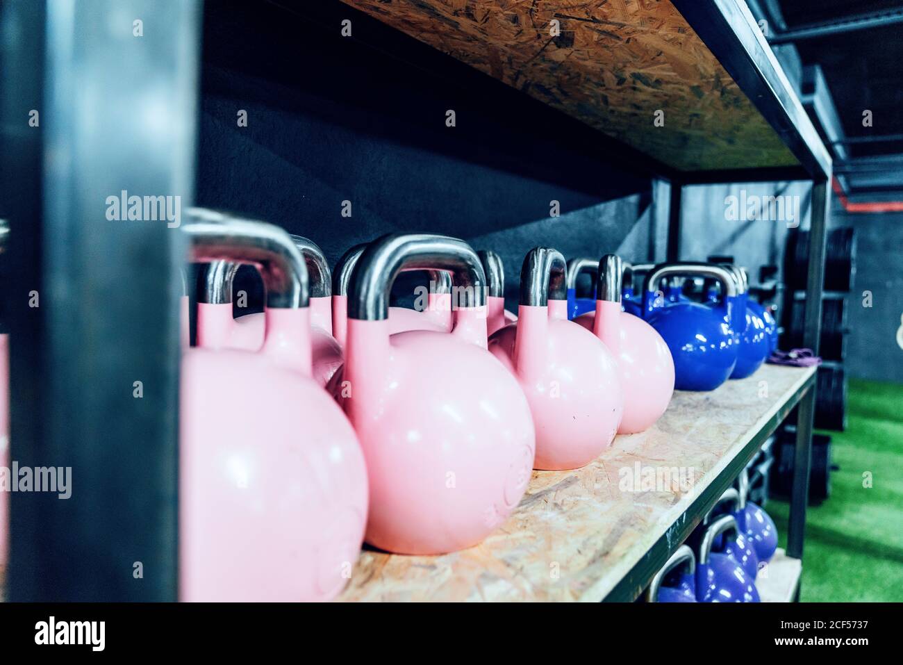 Set di coloratissime kettlebells sugli scaffali del moderno centro benessere Foto Stock