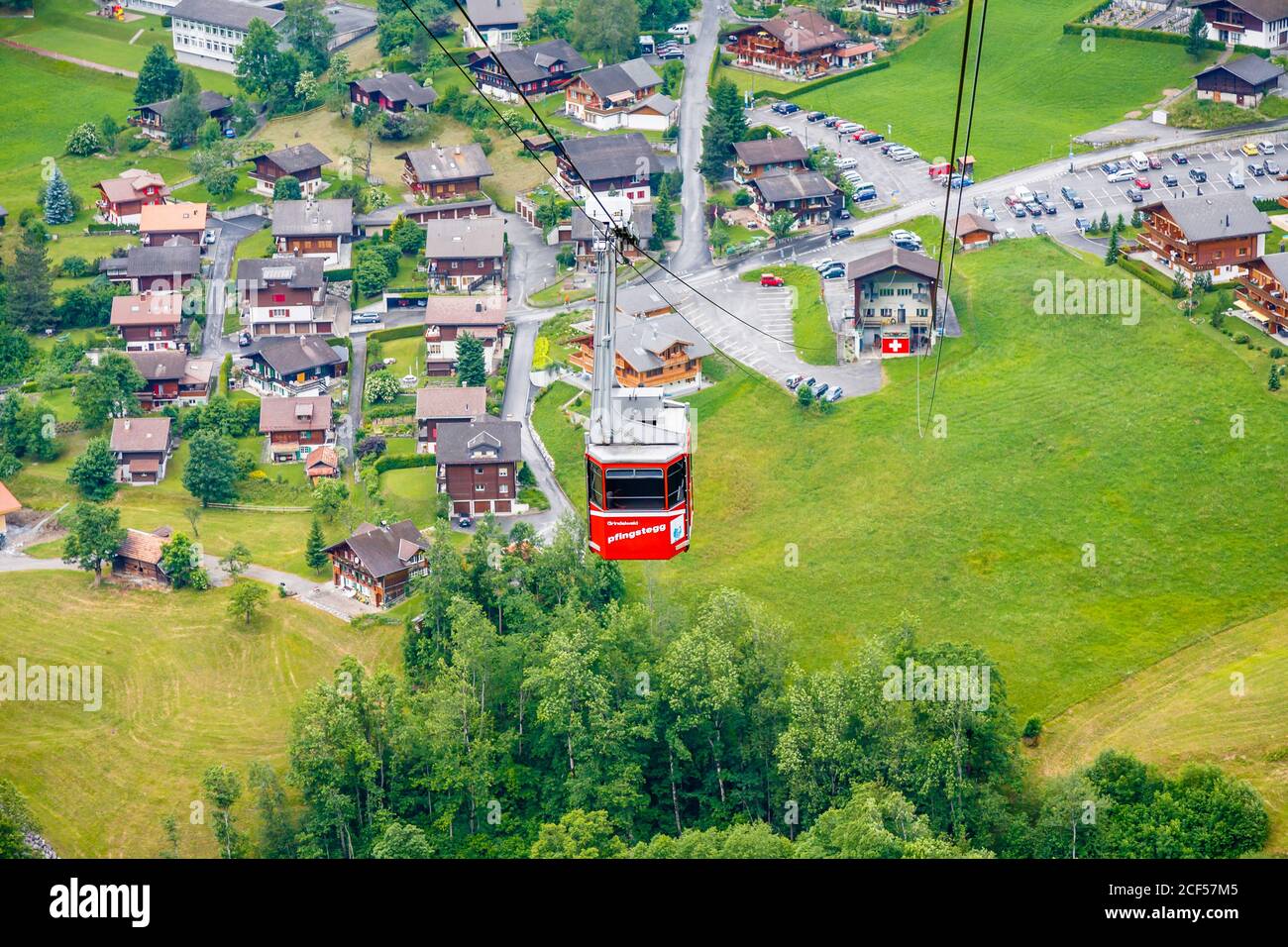 Grindelwald - veduta della funivia rossa di Pfingsteg e della stazione di base, che risale sul villaggio di Grindelwald, Oberland Bernese, Svizzera Foto Stock