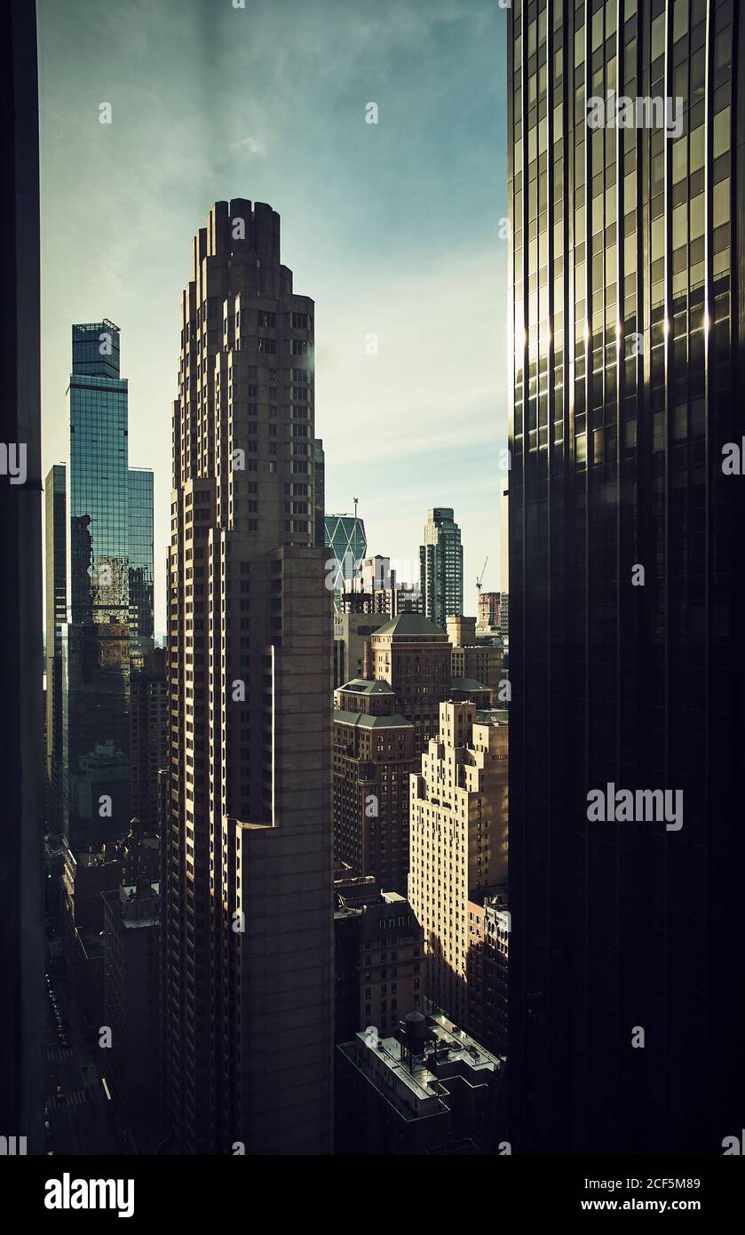 Attraverso la finestra di luccicanti grattacieli torri nel denso distretto di Città di New York alla luce del sole Foto Stock