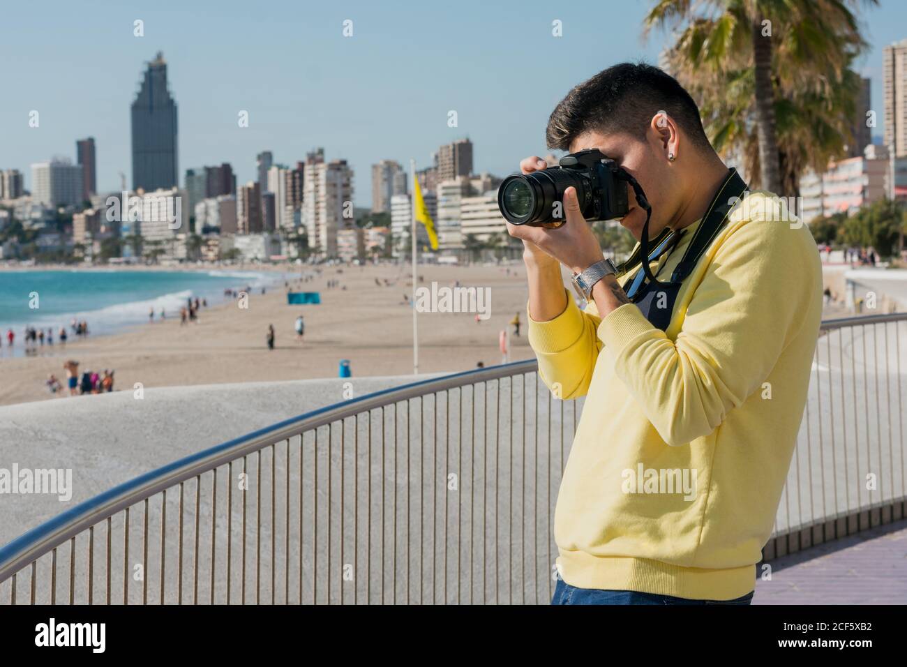 Fotografo giovane e creativo che scatta sul lungomare Foto Stock