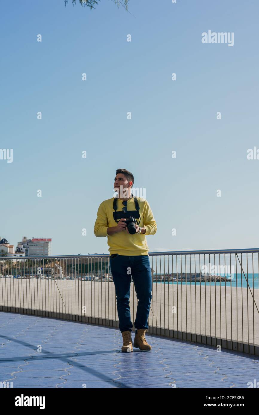 Fotografo giovane e creativo che scatta sul lungomare Foto Stock