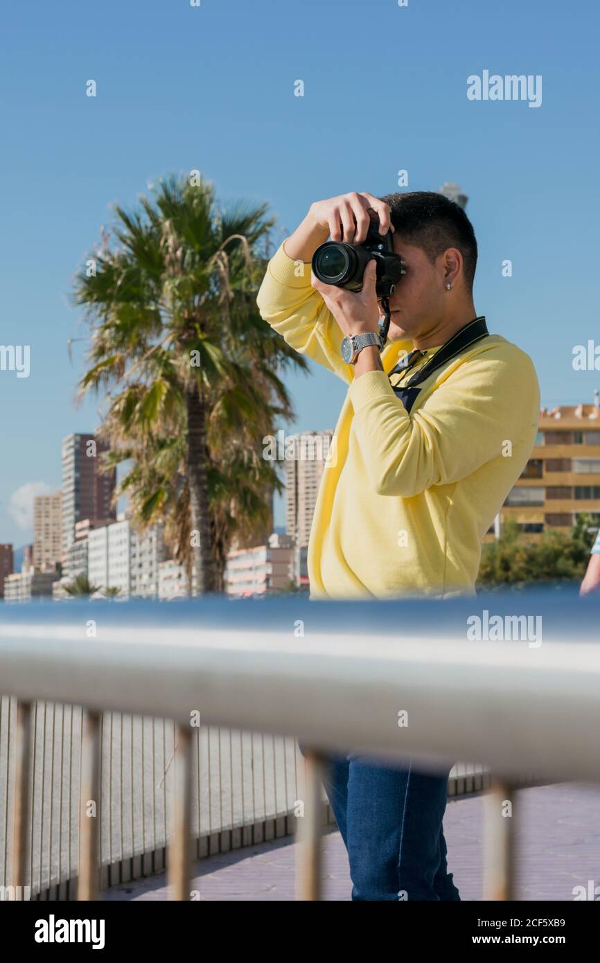 Fotografo giovane e creativo che scatta sul lungomare Foto Stock