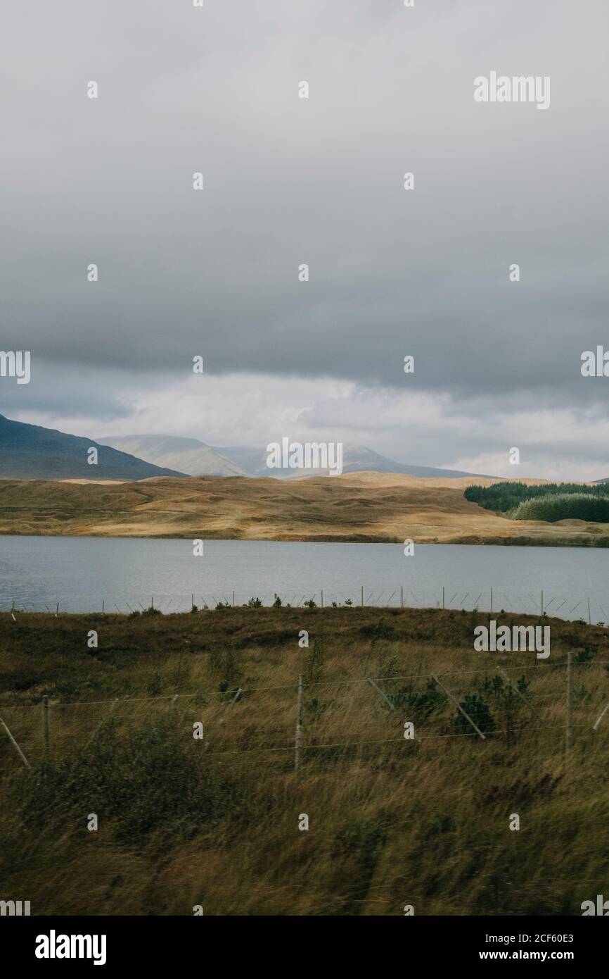 Scenario Scozzese cupo con lago calmo sotto il cielo nuvoloso grigio in altopiano in autunno giorno Foto Stock