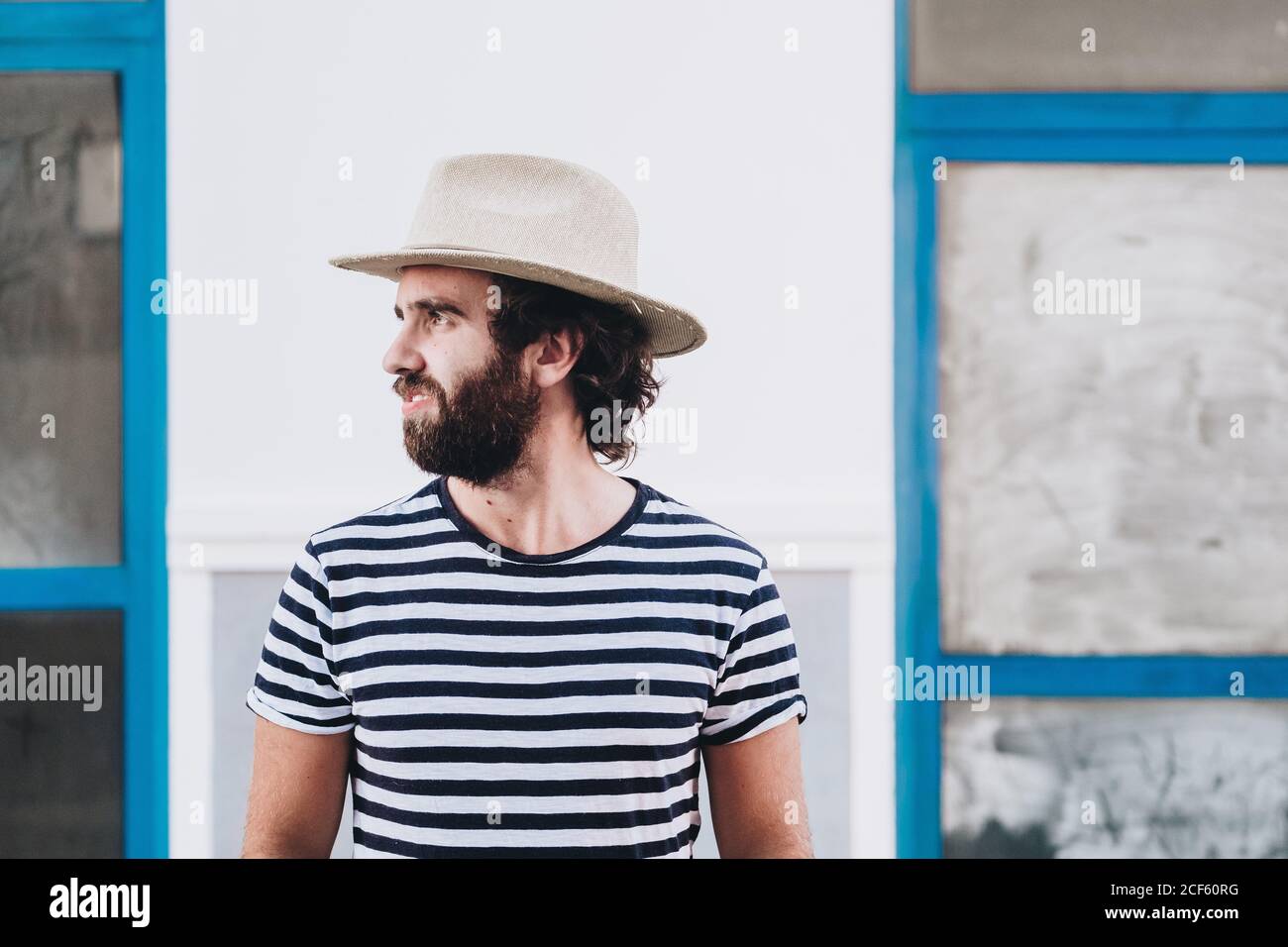 Giovane maschio in cappello e t-shirt a righe Foto Stock