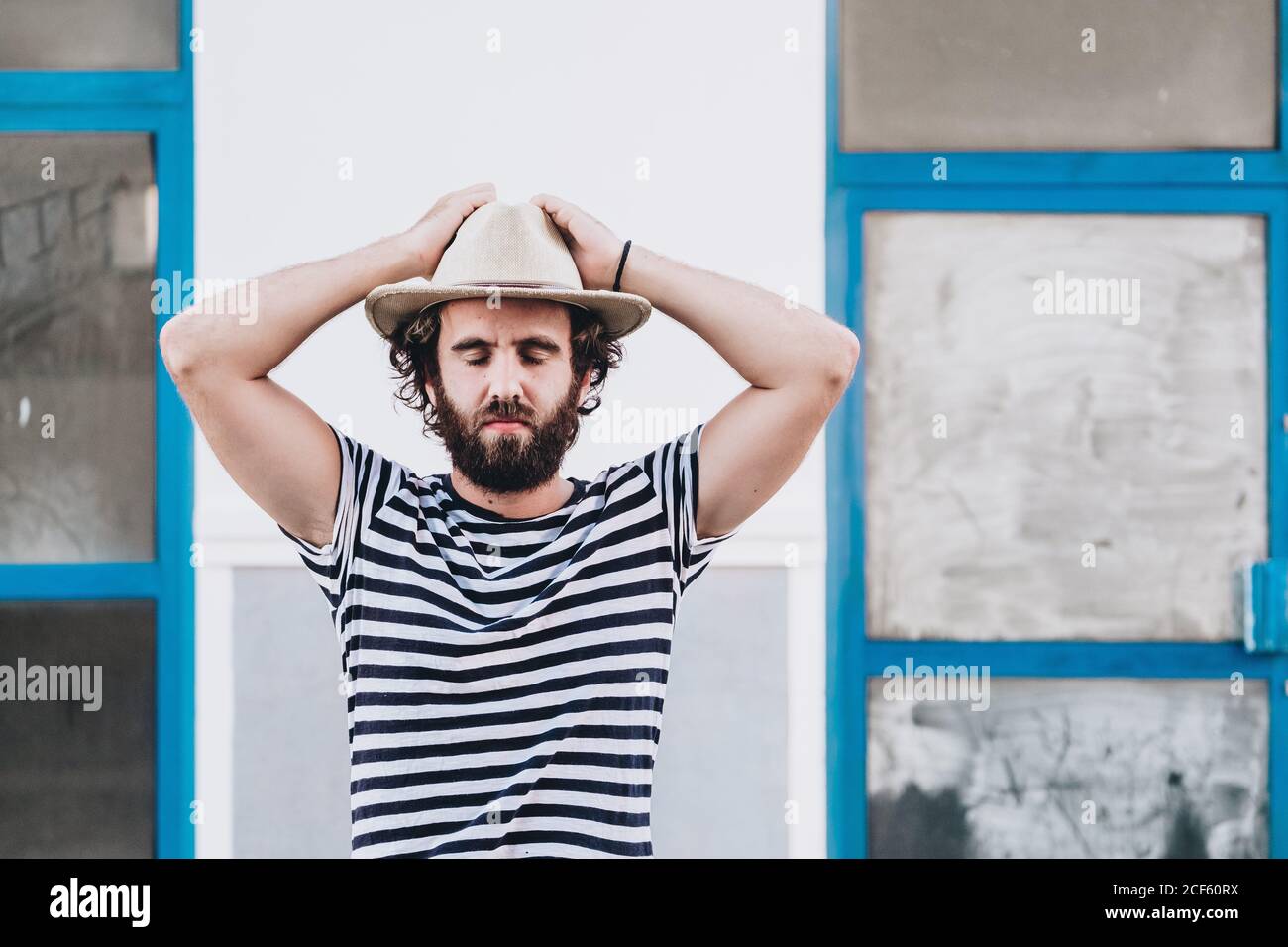 Giovane maschio in cappello e t-shirt a righe Foto Stock