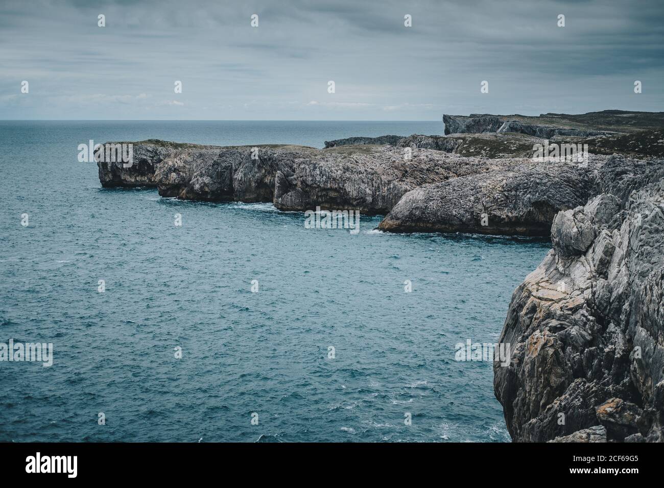 Vista mozzafiato delle scogliere rocciose e del mare turchese sulla nuvolosa giorno Foto Stock