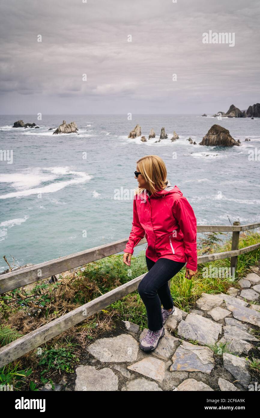 Donna che sale scale che vengono dal mare Foto Stock
