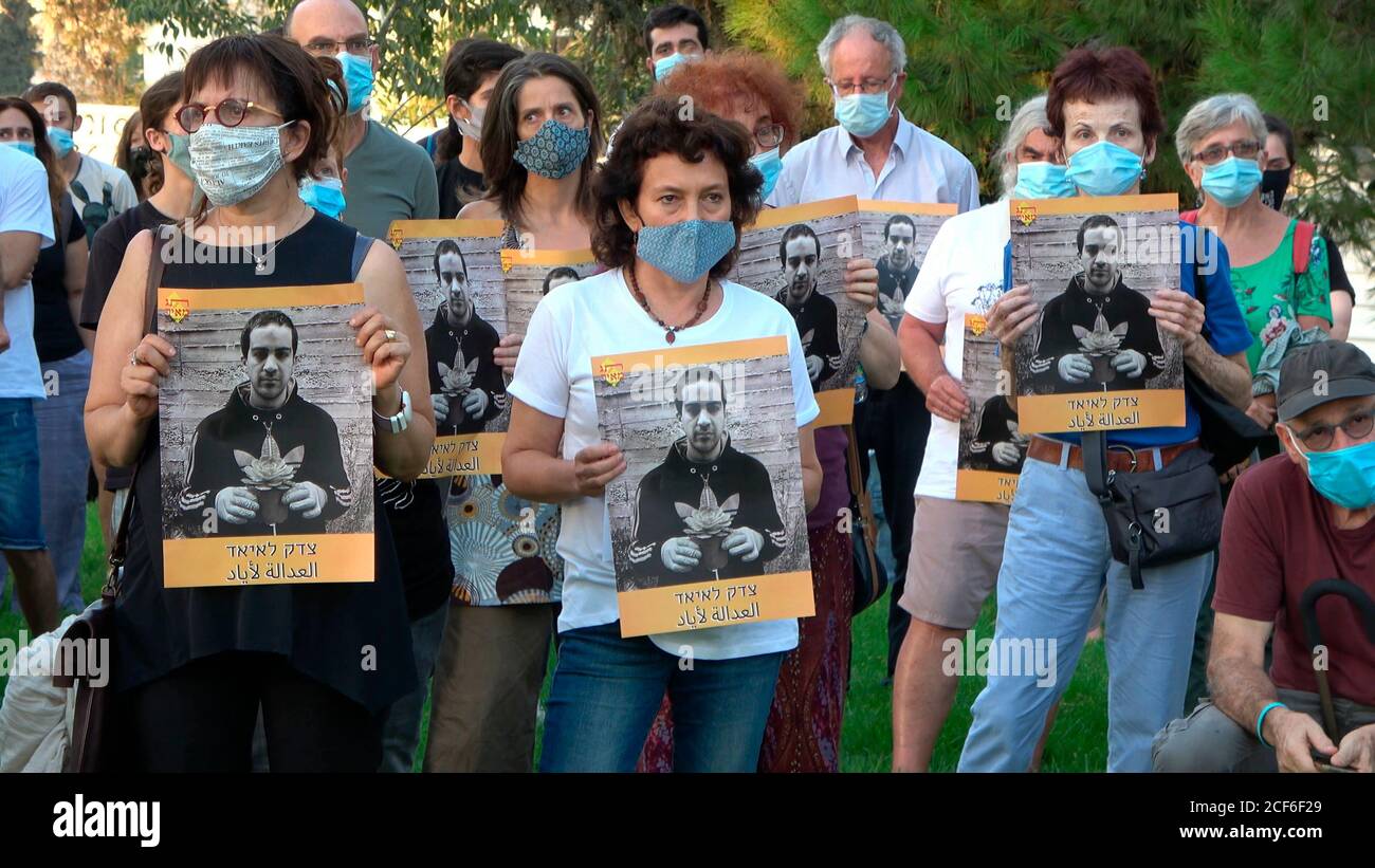 Gli attivisti della pace hanno poster che mostrano la foto di Eyad al-Hallaq palestinese durante una manifestazione tenuta da Israele Tag Meir organizzazione anti-razzismo vicino alla costruzione del Dipartimento di polizia interna che chiede il rilascio di filmati che documentano l'uccisione di Iyad al-Hallak un uomo palestinese con autismo da La polizia israeliana nella città vecchia lo scorso maggio a Gerusalemme, Israele. Foto Stock