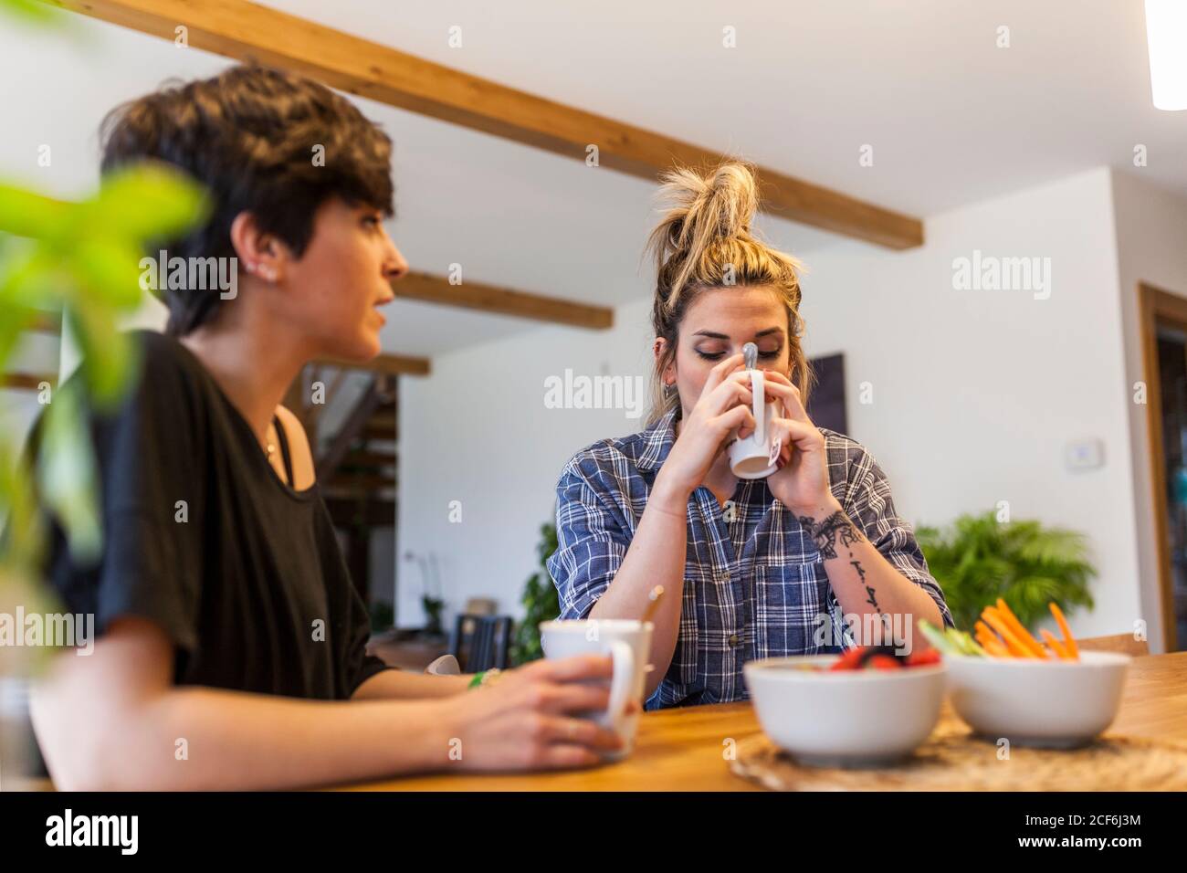 Due belle e giovani donne che fanno colazione a casa e. divertirsi Foto Stock