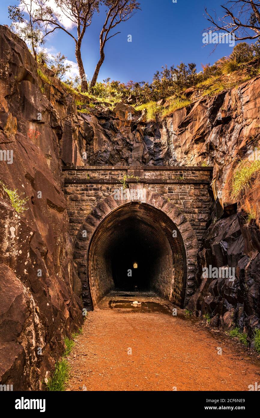 Vecchio tunnel del treno nascosto nel parco nazionale con formazione rocciosa valle Foto Stock