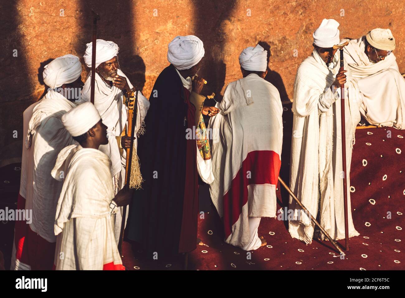 Lalibela, Etiopia - 04 novembre 2018: Gruppo di uomini etnici in abiti bianchi e capo di sacerdote che trasportano i crosiers durante il servizio di preghiera, Etiopia Foto Stock