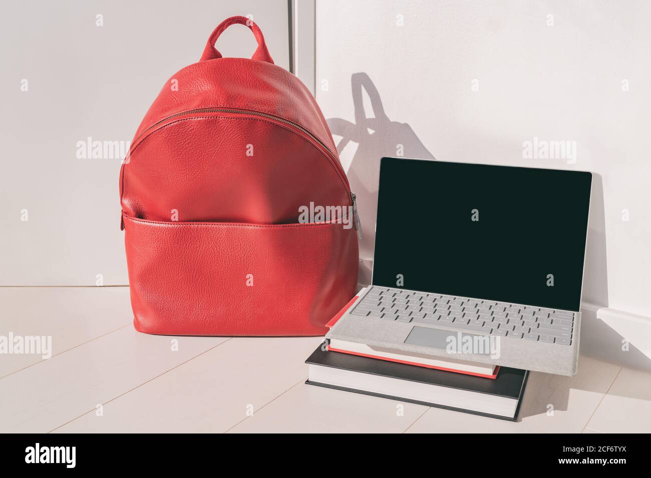 Torna a scuola classi online laptop e zaino rosso con libri di studio, studenti universitari o universitari Foto Stock