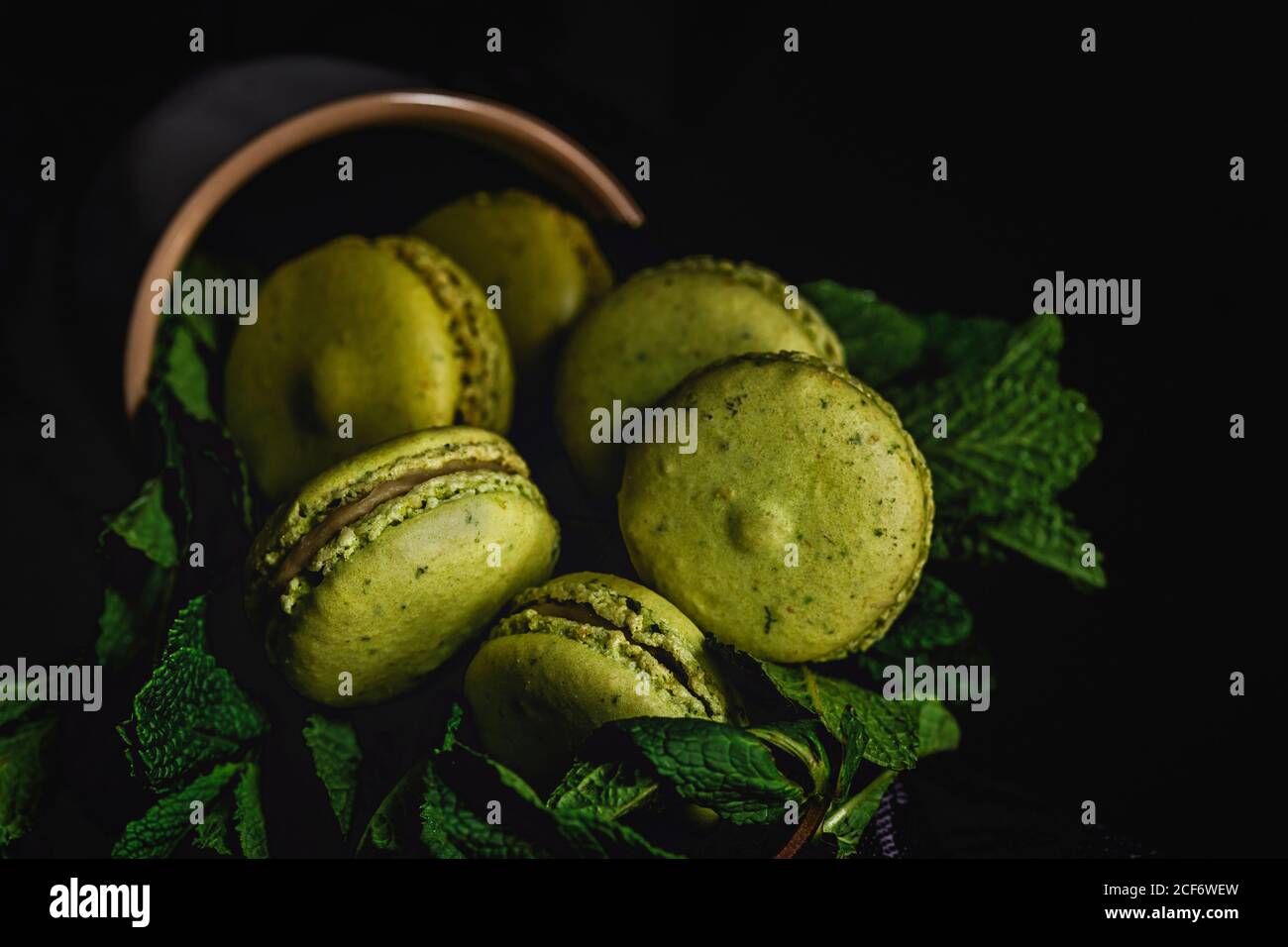 Verde macaron fatto in casa con menta su sfondo scuro. Cibo scuro. Foto Stock