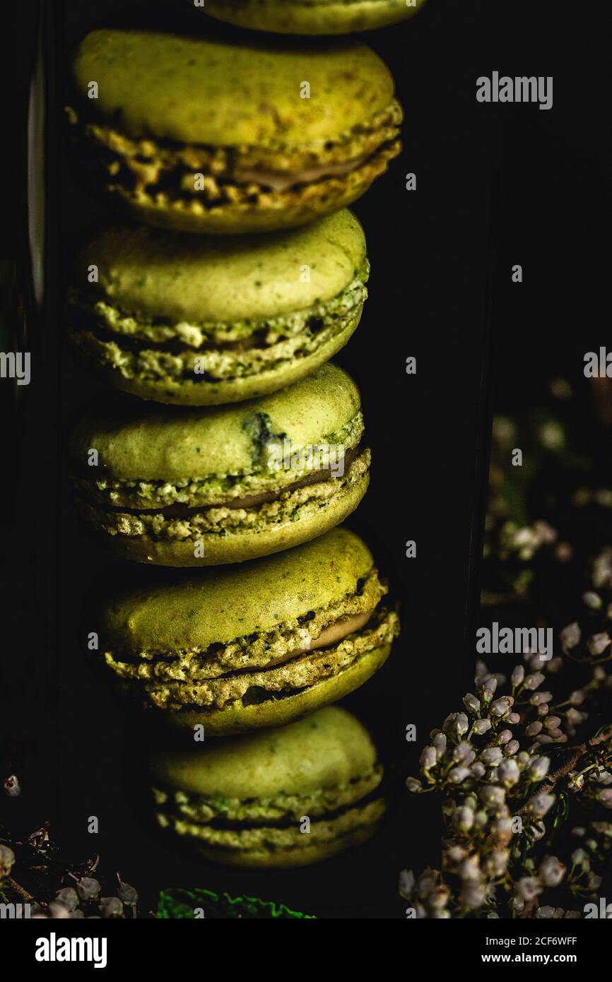 Verde macaron fatto in casa con menta su sfondo scuro. Cibo scuro. Foto Stock