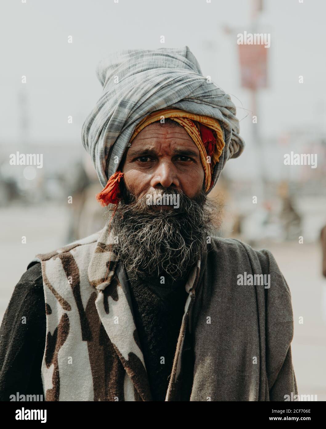 Allahabad, India - FEBBRAIO, 2018: Primo piano ritratto di un anziano indiano che indossa abiti tradizionali contro sfondo sfocato Foto Stock