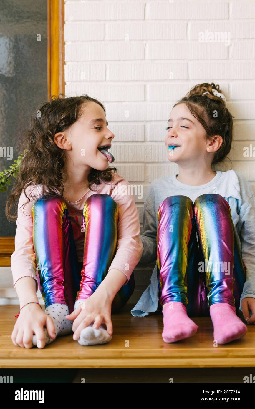Due sorelline sorridenti che attaccano una lingua blu dopo aver mangiato  una gomma blu Foto stock - Alamy