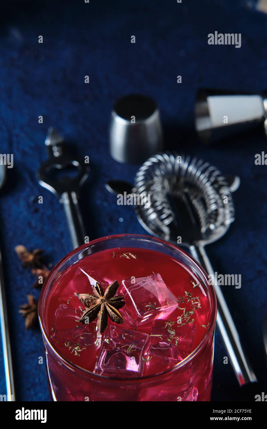 Deliziosi cocktail rossi e utensili da barman sul tavolo Foto Stock