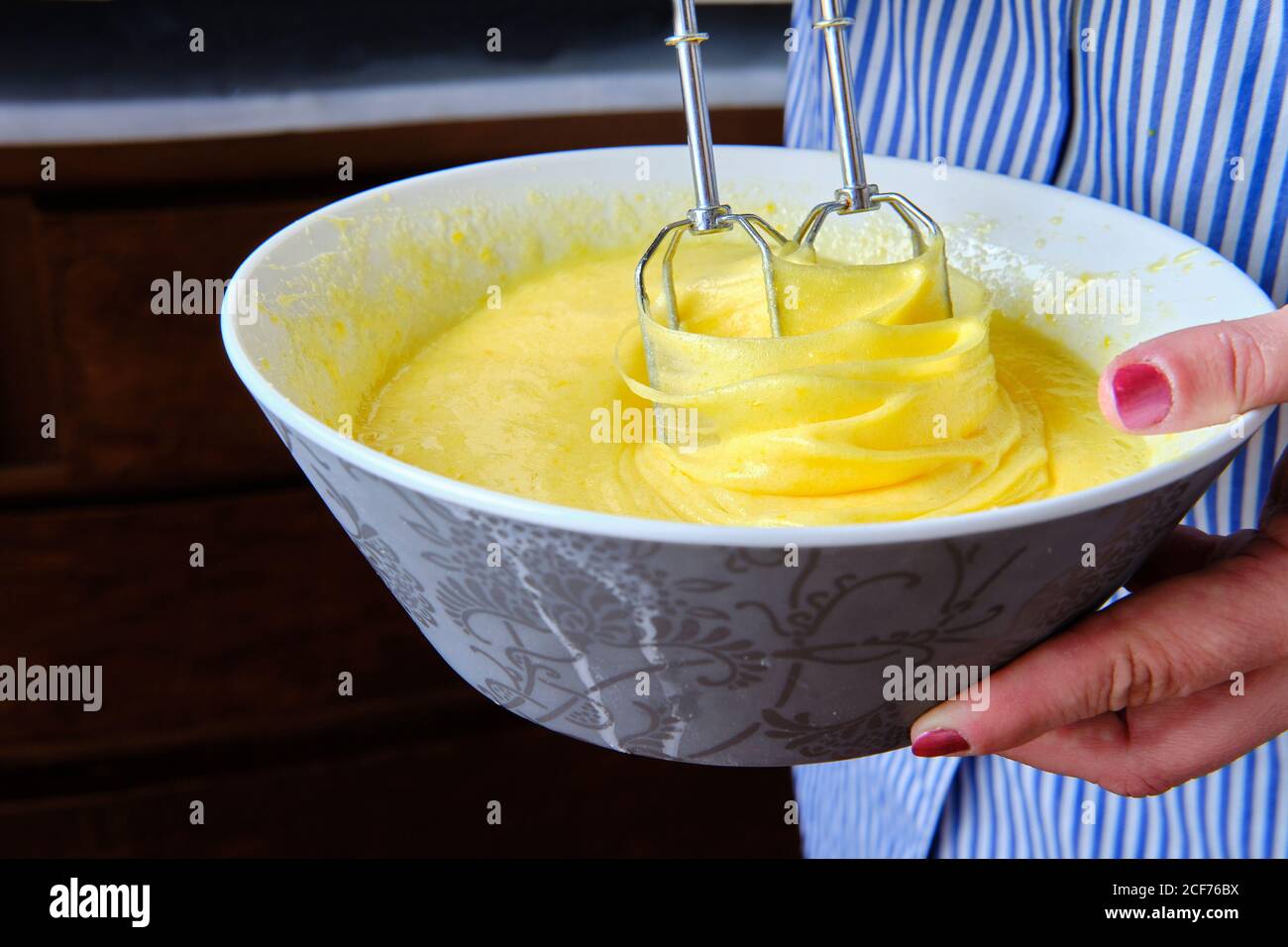 Da sopra anonima Donna uso mixer per preparare pastella per pasticceria in cucina a casa Foto Stock