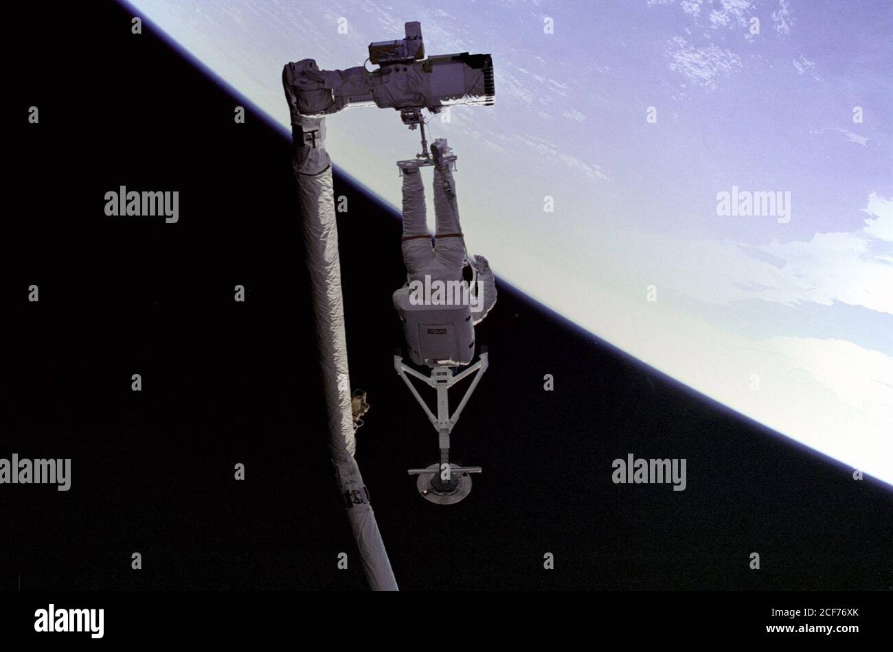 Pierre Thuot, specialista della missione STS-49, è appollaiato sull'effettore finale del braccio del robot (Remote Manipulator System/RMS), con la barra di cattura Intelsat VI. Questo sarebbe uno dei molti tentativi di "aggrappare" il satellite Intelsat VI che è stato reso inoperativo quando il motore del modulo Payload Assist (PAM) non è riuscito a sparare, impedendo così che raggiungesse un'altitudine operativa. Foto Stock