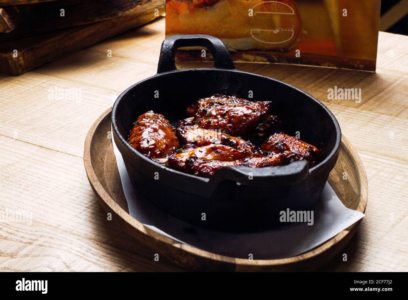 Dall'alto appetitosa carne fritta aromatica cosparsa di verdure teglia spessa in ghisa Foto Stock