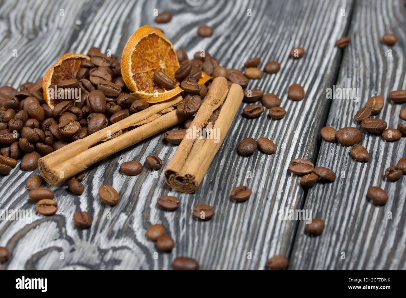 Chicchi di caffè e spezie. Su una superficie di tavole di pino spazzolato dipinte in bianco e nero. Foto Stock