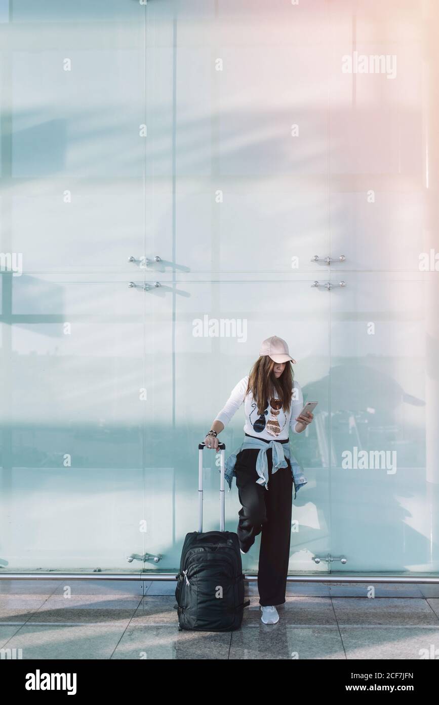 Calma Donna che usa il telefono in aeroporto Foto Stock