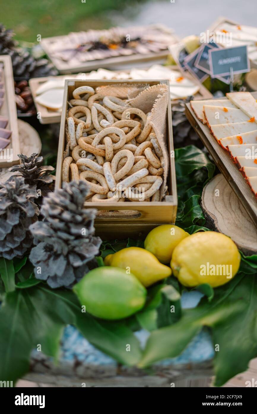 Un angolo alto di bagel yummy messi sul tavolo con assortiti spuntini e citruse Foto Stock